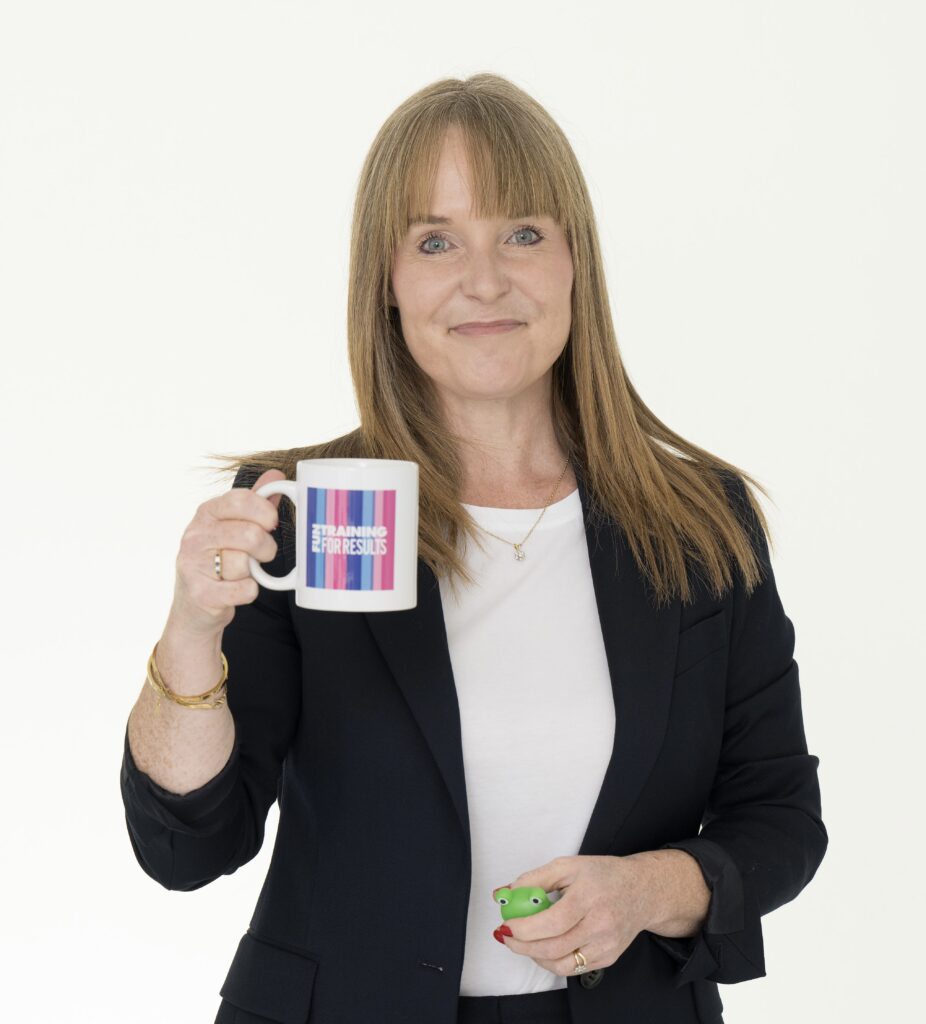 Sally Roberts holding a mug and green frog